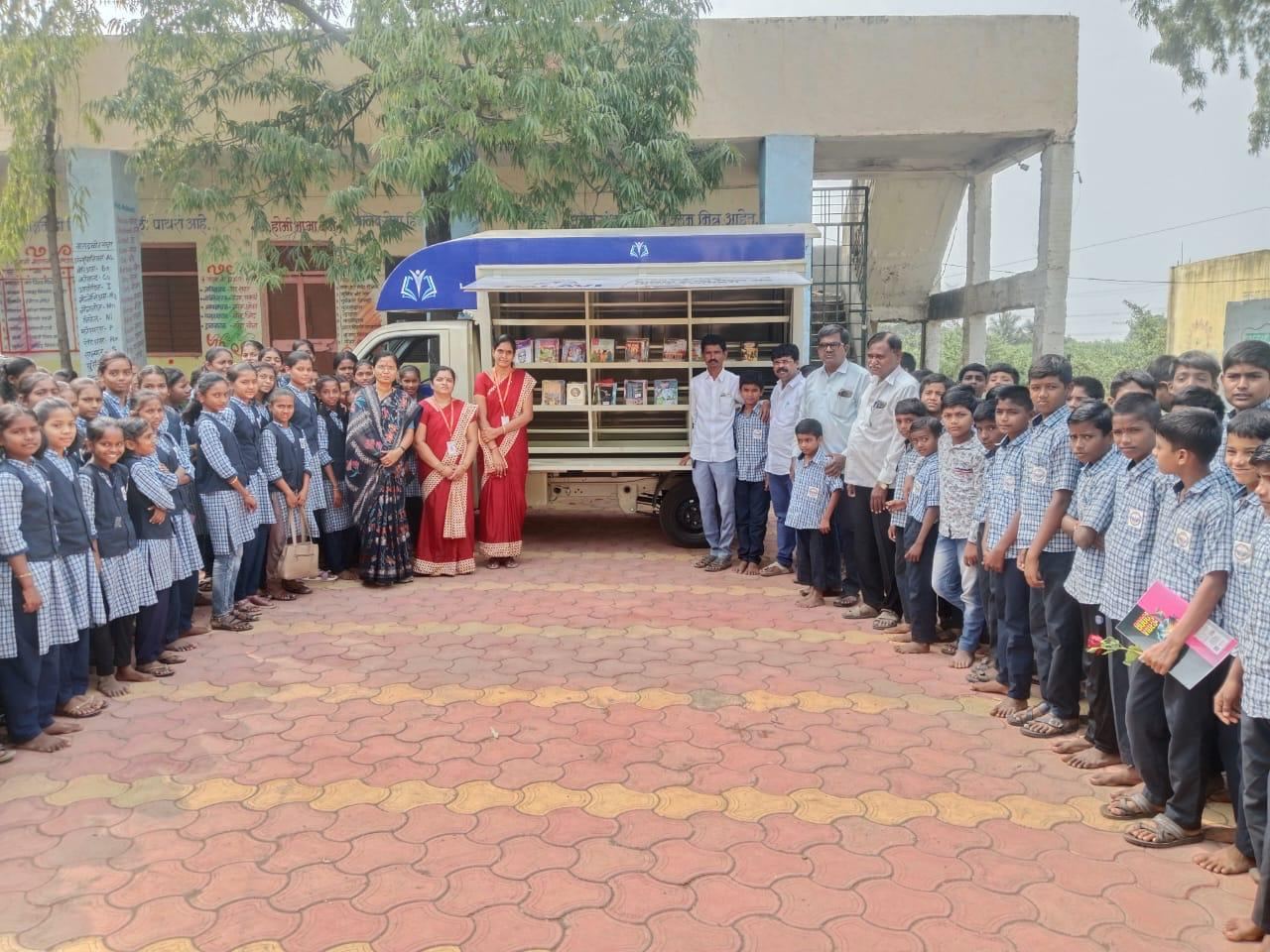 Students gathered around a Palavi mobile library van at their school